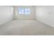 Neutral bedroom with plush carpet, white walls, recessed lights, and bright windows overlooking the street at 16549 Black Rose Cir, Parker, CO 80134