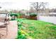 Landscaped backyard featuring a stone patio, green grass, and partial fencing at 5431 S Hickory St, Littleton, CO 80120