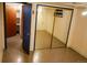 Bedroom with mirrored closet doors, blue trim, and an adjacent closet or room at 5431 S Hickory St, Littleton, CO 80120
