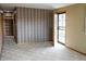 Carpeted living room with striped wallpaper and natural light through the front door at 5431 S Hickory St, Littleton, CO 80120