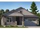 Charming single-story home featuring stone accents, a covered porch, and an attached two-car garage at 657 Nightsky St, Erie, CO 80516