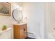 Clean and simple bathroom features a wood vanity and round mirror with a combined shower and tub at 2231 S Vaughn Way # 317 B, Aurora, CO 80014