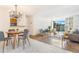 Open-concept living space flows from dining area with hardwood floors to a living room with large windows at 2231 S Vaughn Way # 317 B, Aurora, CO 80014