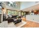 Sunlit living room featuring large windows, hardwood floors, and seamless flow to the kitchen at 360 Morning Star Ln, Lafayette, CO 80026