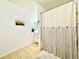 Bright bathroom featuring a tile floor, shower with curtain, and vanity at 12830 Jasmine St # A, Thornton, CO 80602