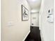 A bright hallway with dark wood floors, light walls and trim and modern light switches and thermostat at 12830 Jasmine St # A, Thornton, CO 80602