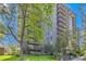 Brick building features a well-maintained lawn, mature trees, and private balconies on each floor at 460 S Marion Pkwy # 102, Denver, CO 80209