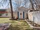 Charming backyard shed with shutters, complemented by a manicured lawn and brick-lined flowerbeds at 4391 S Tabor Ct, Morrison, CO 80465