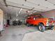 Spacious garage showcases a raised orange truck, an off-road vehicle, and ample storage space at 4391 S Tabor Ct, Morrison, CO 80465