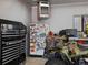 Organized garage featuring tool chest, fridge, and off-road vehicle for functionality and storage at 4391 S Tabor Ct, Morrison, CO 80465