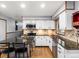 Well-lit kitchen with stainless steel appliances, granite counters, and an island with seating at 4391 S Tabor Ct, Morrison, CO 80465