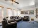 Comfortable living room featuring a ceiling fan, plush seating, and windows for natural light at 4391 S Tabor Ct, Morrison, CO 80465