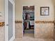 Bright walk-in closet with shelving, drawers and a door with translucent glass panel at 4391 S Tabor Ct, Morrison, CO 80465