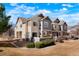 Townhouse exterior features a well-maintained lawn, beautiful facade, and a combination of stone and siding accents at 15800 E 121St Ave # 4G, Brighton, CO 80603