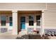 Exterior view of the home's front entrance featuring a vibrant blue door, covered porch, and manicured landscaping at 15800 E 121St Ave # 4G, Brighton, CO 80603