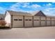 Row of garages showcasing ample parking space and neutral color scheme with contrasting stone accents at 15800 E 121St Ave # 4G, Brighton, CO 80603