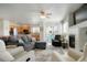 Open-concept living room boasts a gray sofa, ceiling fan, fireplace and seamless access to the kitchen and outdoor area at 15800 E 121St Ave # 4G, Brighton, CO 80603
