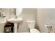 Cozy powder room featuring pedestal sink, round mirror, and modern toilet at 15800 E 121St Ave # 4G, Brighton, CO 80603