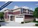 Two-story house with maroon and beige siding, a two-car garage, and landscaping at 22321 E 38Th Pl, Aurora, CO 80019