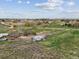 Wide aerial shot of the acreage displaying the home, outbuildings, and surrounding natural terrain at 3559 Meadow Ln, Brighton, CO 80603