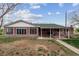 Expansive backyard showcases a brick home with a covered patio, ideal for outdoor entertaining and relaxation at 3559 Meadow Ln, Brighton, CO 80603