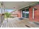 Back deck of brick house with brick facade and open space, leading in through sliding glass door at 3559 Meadow Ln, Brighton, CO 80603