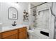 Stylish bathroom featuring a wood vanity, marble tiling in the bathtub/shower area, and floating shelves at 3559 Meadow Ln, Brighton, CO 80603