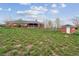 Exterior view of brick home with green roof, grassy yard and a brick storage shed at 3559 Meadow Ln, Brighton, CO 80603