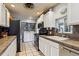 Well-lit kitchen featuring white cabinets, stainless steel appliances, and convenient washer and dryer at 3559 Meadow Ln, Brighton, CO 80603