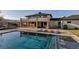 Expansive backyard with large pool and stone columns, featuring outdoor fireplace and lounge chairs at 15902 W 64Th Ave, Arvada, CO 80007