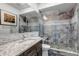 Modern bathroom featuring a glass-enclosed shower, sleek vanity, and stylish tiling at 15902 W 64Th Ave, Arvada, CO 80007