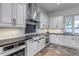 Beautiful kitchen features modern, stainless steel appliances, gray cabinets and wood floor at 15902 W 64Th Ave, Arvada, CO 80007