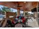 Cozy outdoor patio with a fireplace, seating, dining, and a mounted TV for outdoor entertaining at 15902 W 64Th Ave, Arvada, CO 80007