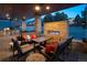 Outdoor patio area featuring a built-in fireplace, outdoor kitchen, and ample seating with a view of the pool at 15902 W 64Th Ave, Arvada, CO 80007