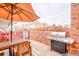 Cozy patio area with a grill, dining set, brick privacy wall, and a shaded outdoor space at 1150 Inca St # 39, Denver, CO 80204