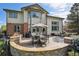 An outdoor seating area on the back patio with built-in grill and lush, landscaped yard at 14417 W 57Th Pl, Arvada, CO 80002