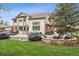 Spacious backyard featuring a stone patio with a fire pit and manicured lawn at 14417 W 57Th Pl, Arvada, CO 80002