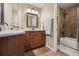 Bathroom with granite countertop, wood cabinets, and tiled shower/tub combo at 14417 W 57Th Pl, Arvada, CO 80002