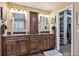 Elegant bathroom with double vanities, granite countertop, and access to a walk-in closet at 14417 W 57Th Pl, Arvada, CO 80002