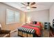 Bright bedroom with ceiling fan, window with blinds, and modern furnishings at 14417 W 57Th Pl, Arvada, CO 80002