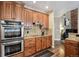 Modern kitchen featuring wood cabinetry, granite countertops, and stainless steel appliances at 14417 W 57Th Pl, Arvada, CO 80002