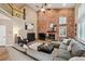 Spacious living room with a soaring brick fireplace, vaulted ceiling, and comfortable seating at 14417 W 57Th Pl, Arvada, CO 80002