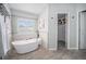 Bathroom featuring modern white soaking tub, tile flooring, and decorative wall art at 17548 E Wesley Pl, Aurora, CO 80013