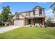 This two-story home offers a charming exterior with a lush lawn, brick accents, and an attached two-car garage at 17548 E Wesley Pl, Aurora, CO 80013