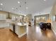 Open-concept kitchen featuring a large island, modern appliances, pendant lighting, and hardwood floors at 668 E Dry Creek Cir, Littleton, CO 80122