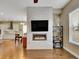 Contemporary living room with tile wall, fireplace, TV, hardwood floors, and kitchen in background at 668 E Dry Creek Cir, Littleton, CO 80122