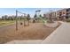 Community playground featuring swings, a slide, and climbing structure surrounded by a wood chip safety surface at 668 E Dry Creek Cir, Littleton, CO 80122