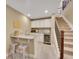A finished basement with a bar area that includes a sink, wine fridge and storage beneath the staircase at 668 E Dry Creek Cir, Littleton, CO 80122