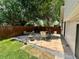Landscaped backyard featuring a stone patio with garden, dining set, and surrounding privacy fence at 45 Pierce St, Lakewood, CO 80226
