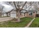 Well-maintained home with brick accents, green lawn, and mature tree in the front yard at 45 Pierce St, Lakewood, CO 80226
